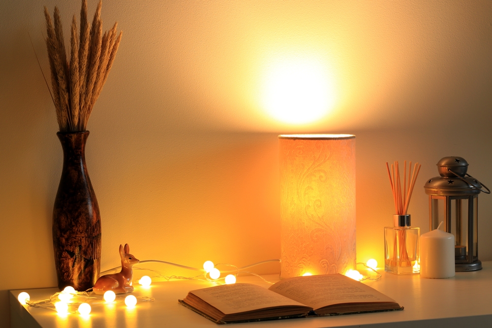 Warm lamp on table with string lights ©Jurjanephoto