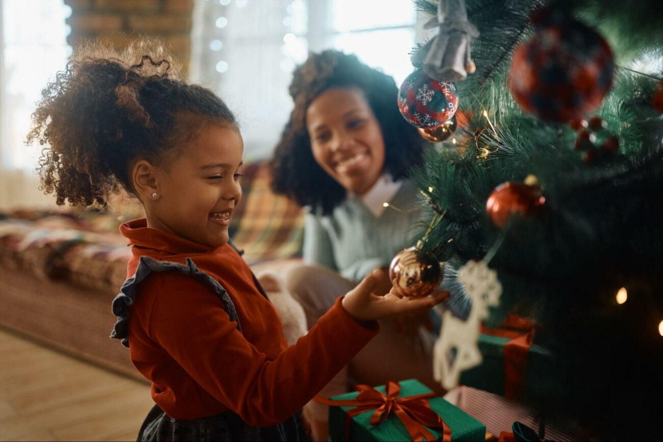 Little kid and mom decorating the christmas tree ©Drazen Zigic