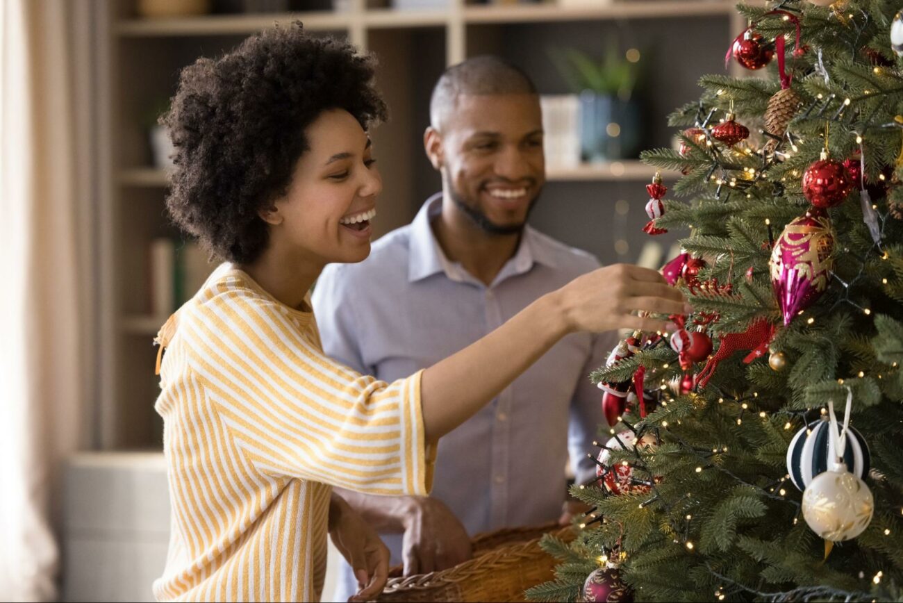 Couple putting ornaments on the tree ©fizkes